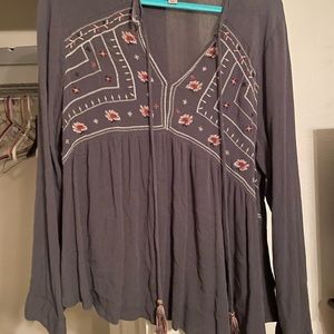 Gray blouse. Is loose fitting but short in the front. Not see through.